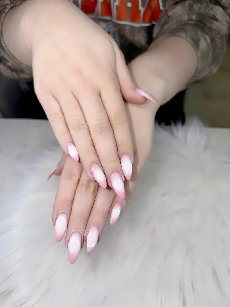 Soft pink and white French nails on a plush white background