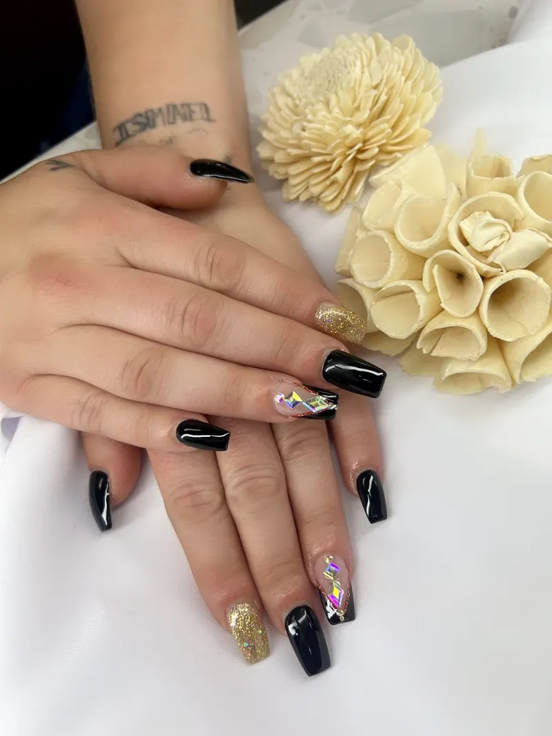 Black and gold glitter coffin nails with crystal accents by Beauty Nails Spa
